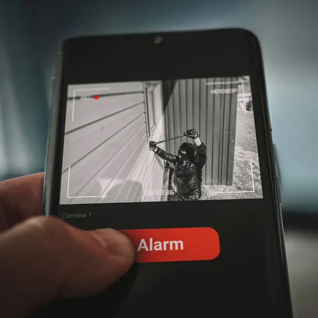 Phone showing a live camera view and a security alert